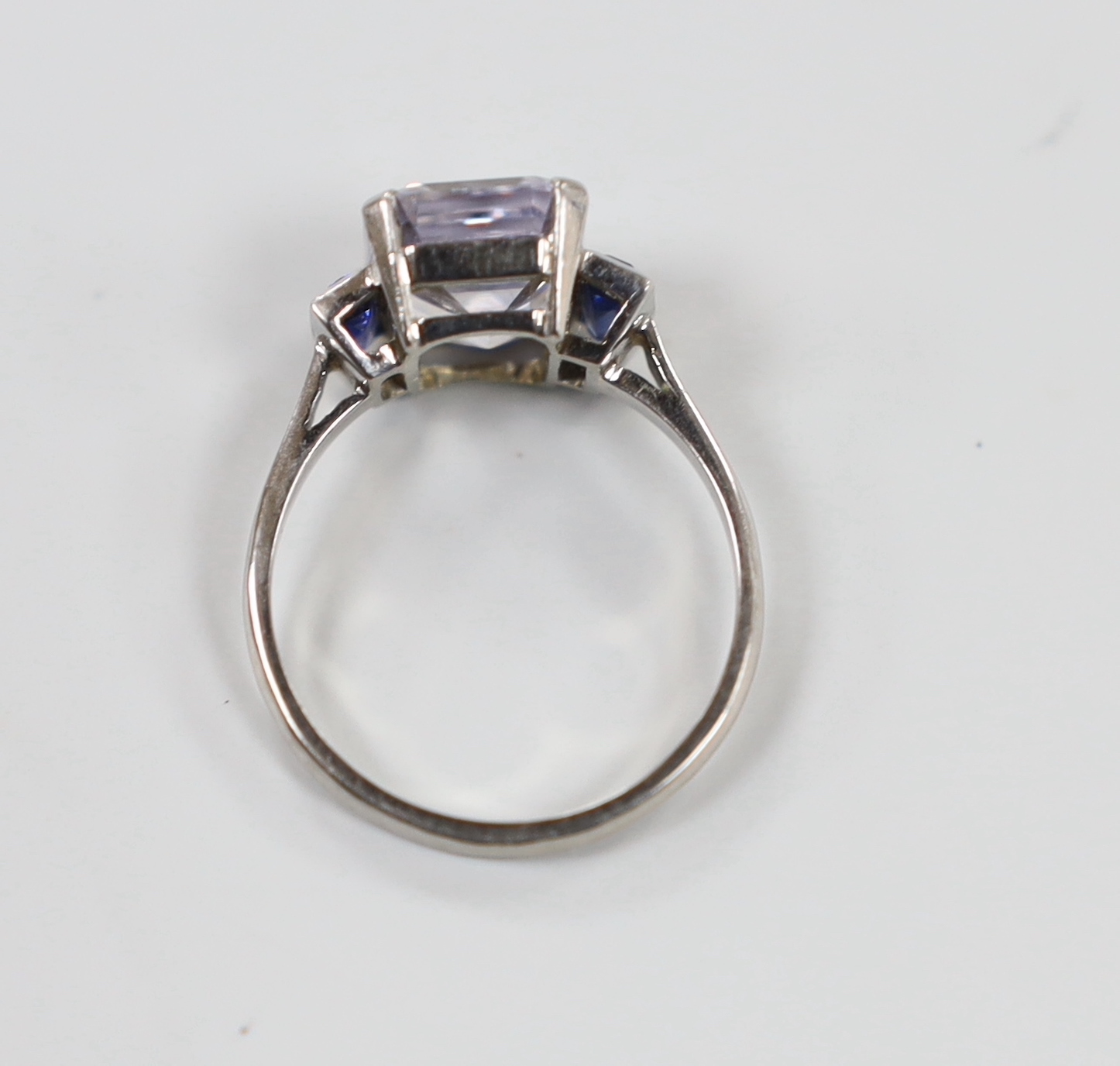 A white metal and two colour sapphire set three stone ring, size N, gross weight 3.8 grams.